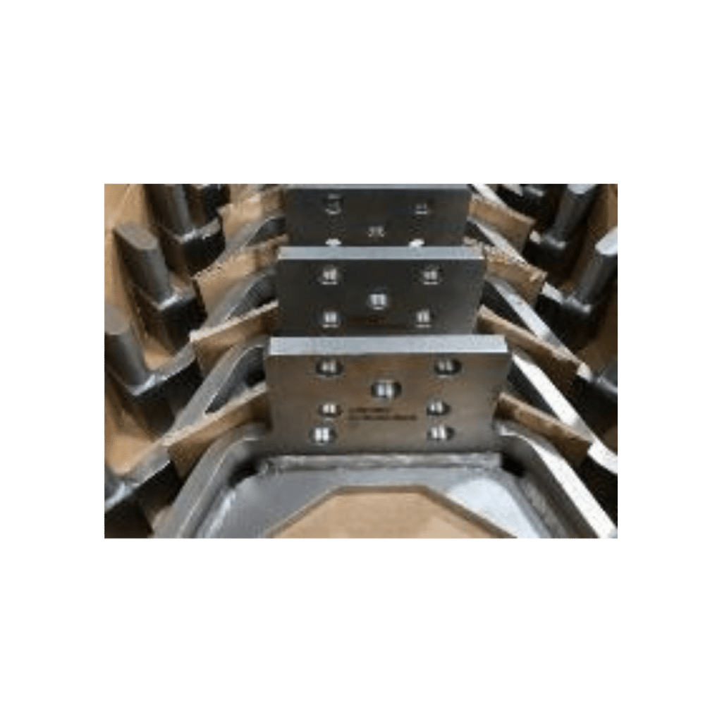 "Industrial metal mold components with geometric designs stacked in a workshop setting."