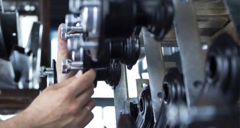 "Close-up of a technician's hands adjusting components on a mechanical assembly line, showcasing precision and attention to detail."